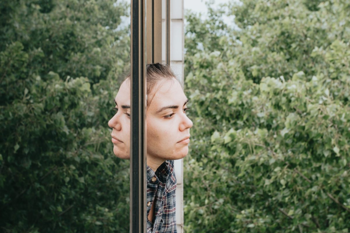 Woman worried while showing off the window in the city during a spring day, mental health concept